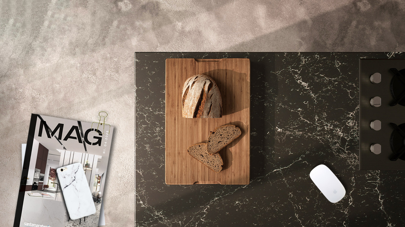 Piano nero in marmo di una cucina con tagliere con pane tagliato, cataloghi e fondo grigio in quarzo