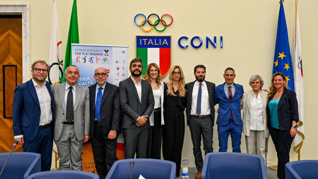 Gruppo di persone con logo CONI e tricolore sullo sfondo