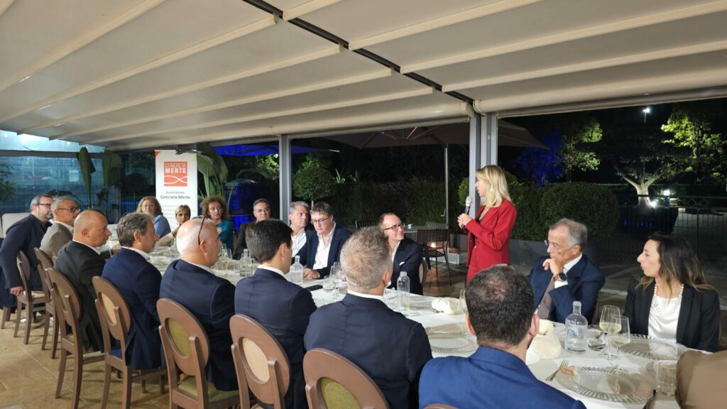 persone sedute a tavola, Paola Castellacci parla in piedi con il microfono
