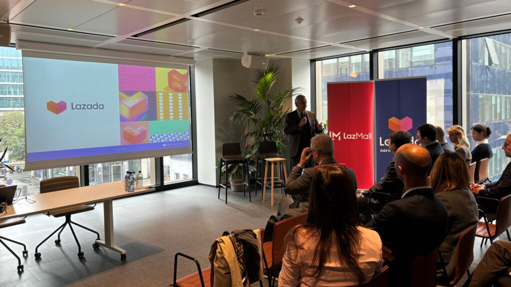 sala con persone sedute e proiezione presentazione della piattaforma Lazada